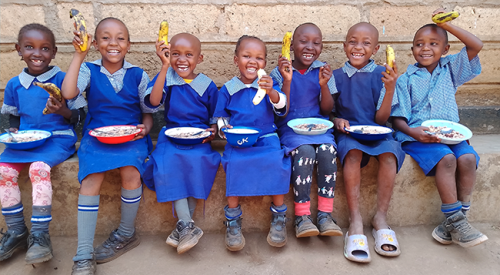 children enjoying hot meals in Kenya
